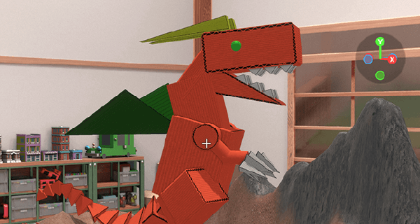 子供部屋の中を、段ボールで作られた、緑の目、緑の羽を持つ赤いドラゴンが岩山の中を歩いている画像